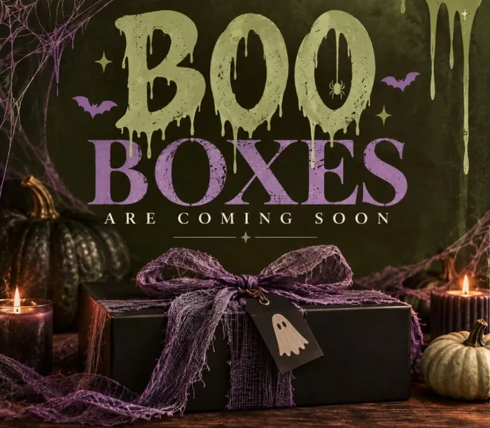 Boo Boxes are coming soon: dripping slime-green and purple lettering above a black gift box tied with purple gauze and a ghost tag, between candles and pumpkins.