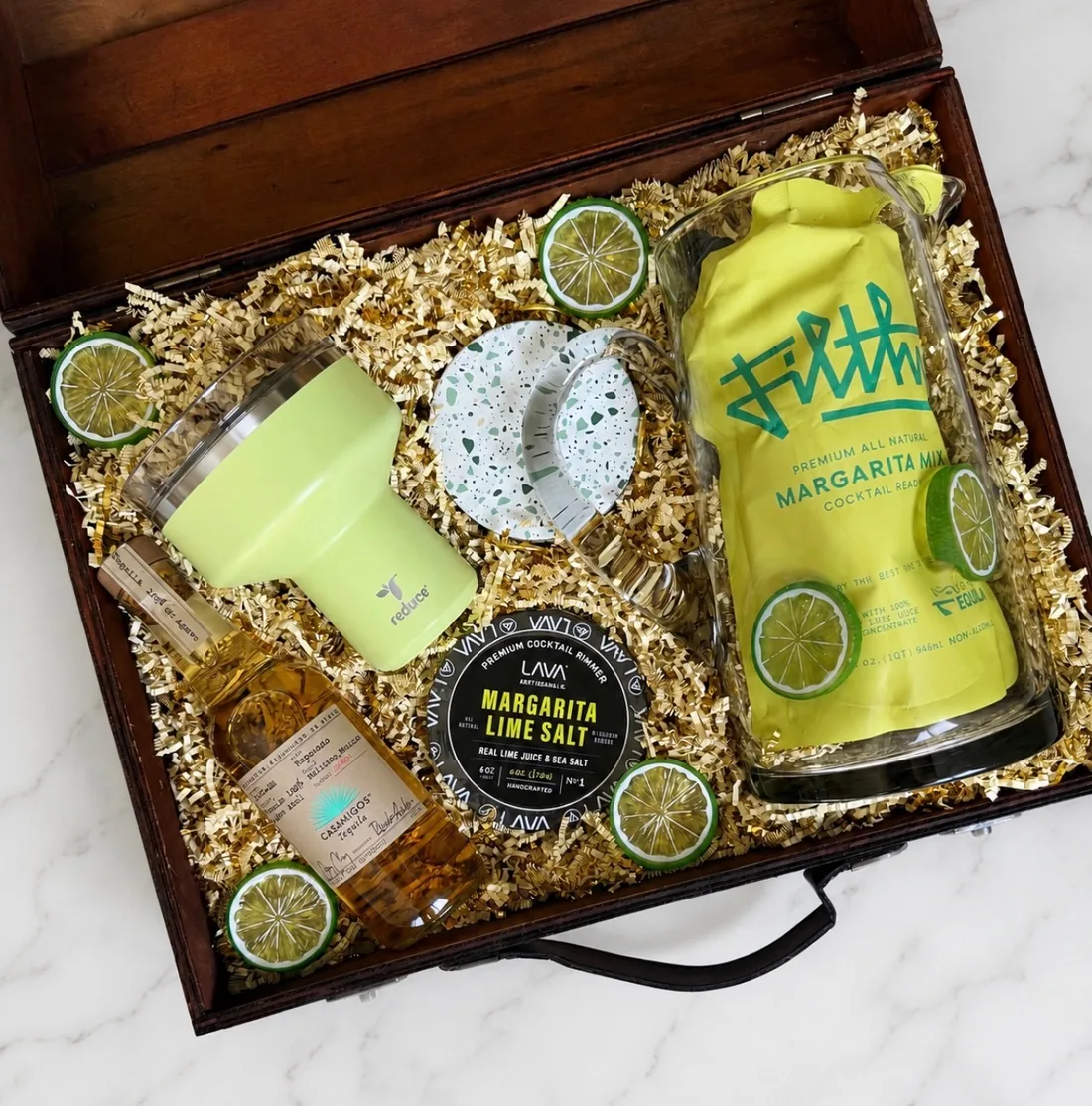 Margarita gift box: a walnut keepsake case packed with a chartreuse tumbler, margarita mix, tequila, lime salt rimmer, and terrazzo coasters in gold crinkle paper